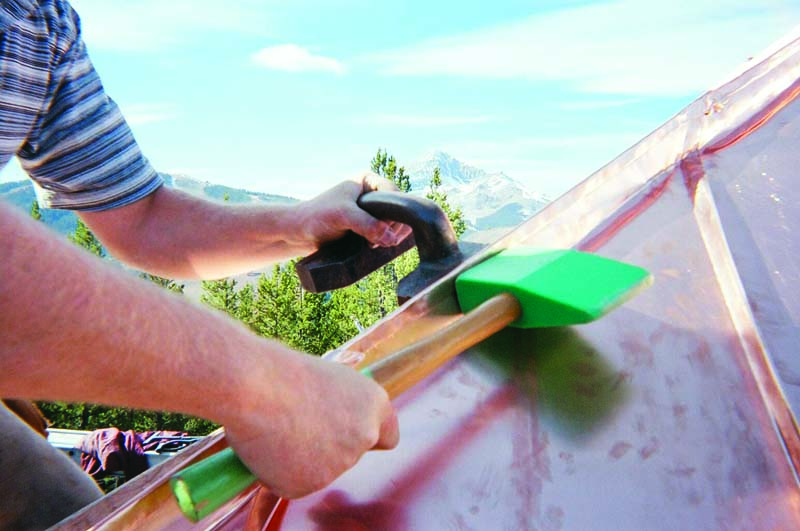 Mike Winters, owner of Mike’s Metal Works in Bozeman, Montana, uses hand seamers (top) and a mallet to seam copper standing seam panels on this Montana residential jobsite.  MIKE’S METAL WORKS PHOTOS