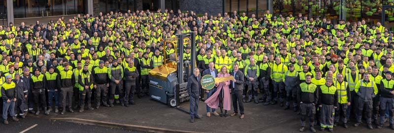 A momentous occasion, Kareen Farrell receives her “Golden Forklift” as the Combilift team looks on.