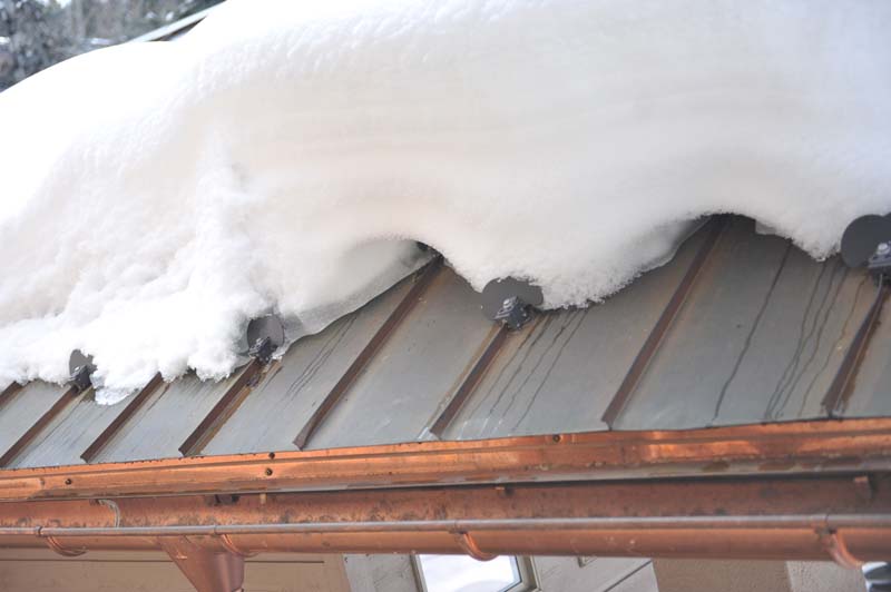 Combining snow guards and a heated cable system provides an efficient snow and ice management system on metal roofs. Photo courtesy of FloTrace